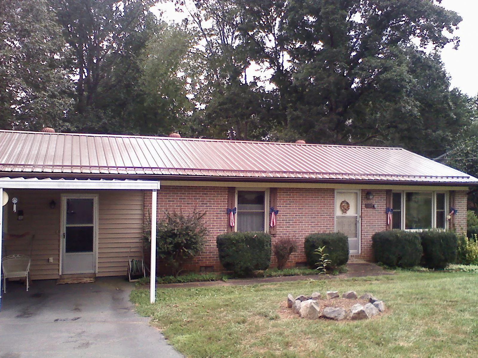 Bronze metal roof and carport on a brick ranch home — Roof Repair work by our crew in Scarville